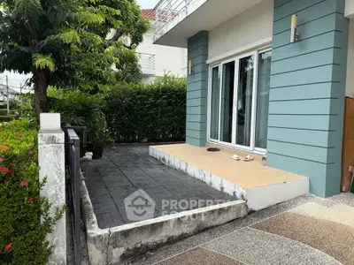 Modern house exterior with stylish patio and lush greenery, perfect for outdoor relaxation.