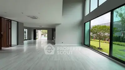 Spacious modern living room with large windows and garden view, perfect for luxury living.