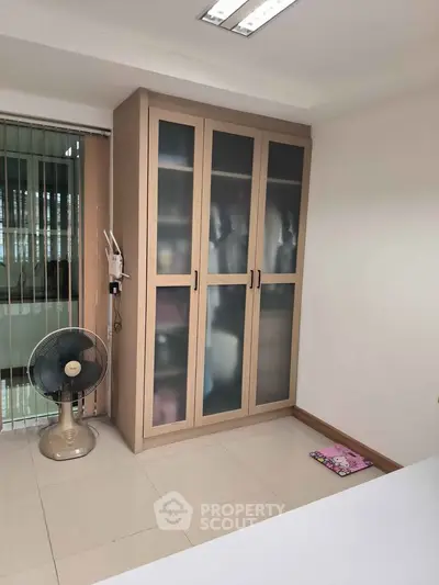 Spacious bedroom with modern wardrobe and sleek tile flooring