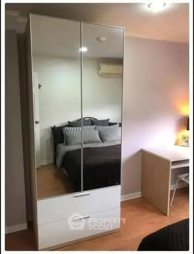 Cozy bedroom with mirrored wardrobe and study desk, perfect for modern living.