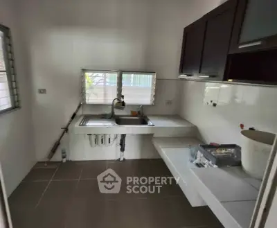 Compact kitchen with modern cabinetry and dual windows for natural light
