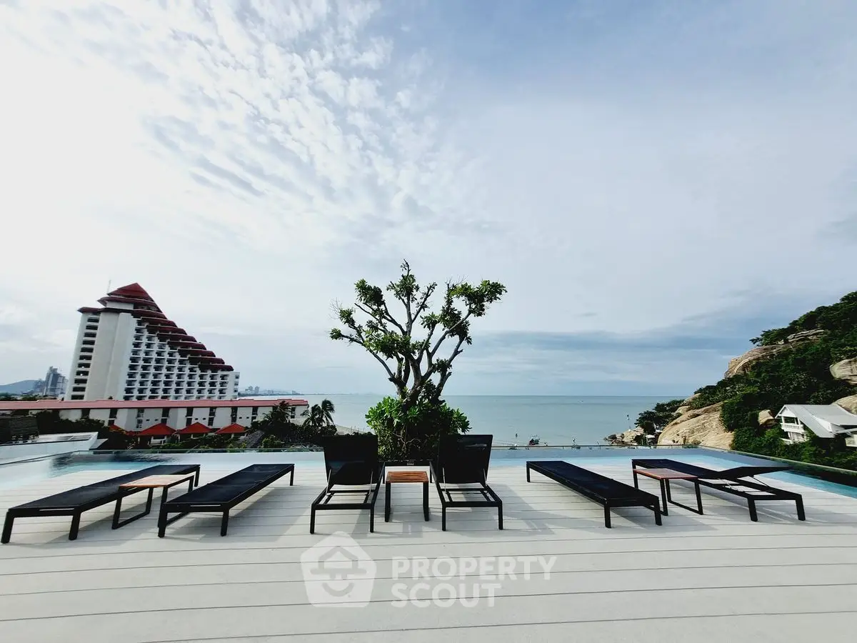 Stunning rooftop pool with panoramic ocean views and modern lounge chairs.