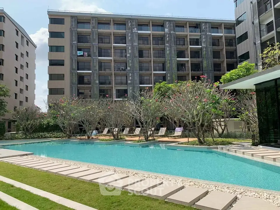 Luxurious apartment complex with stunning pool and lush greenery, perfect for modern living.