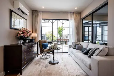 Elegant living room with large windows and stylish decor, perfect for modern living.