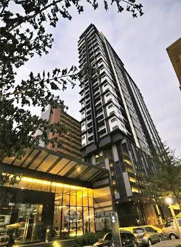 Modern high-rise building with glass facade and evening lights