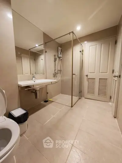 Modern bathroom with glass shower enclosure and sleek fixtures in a contemporary home.