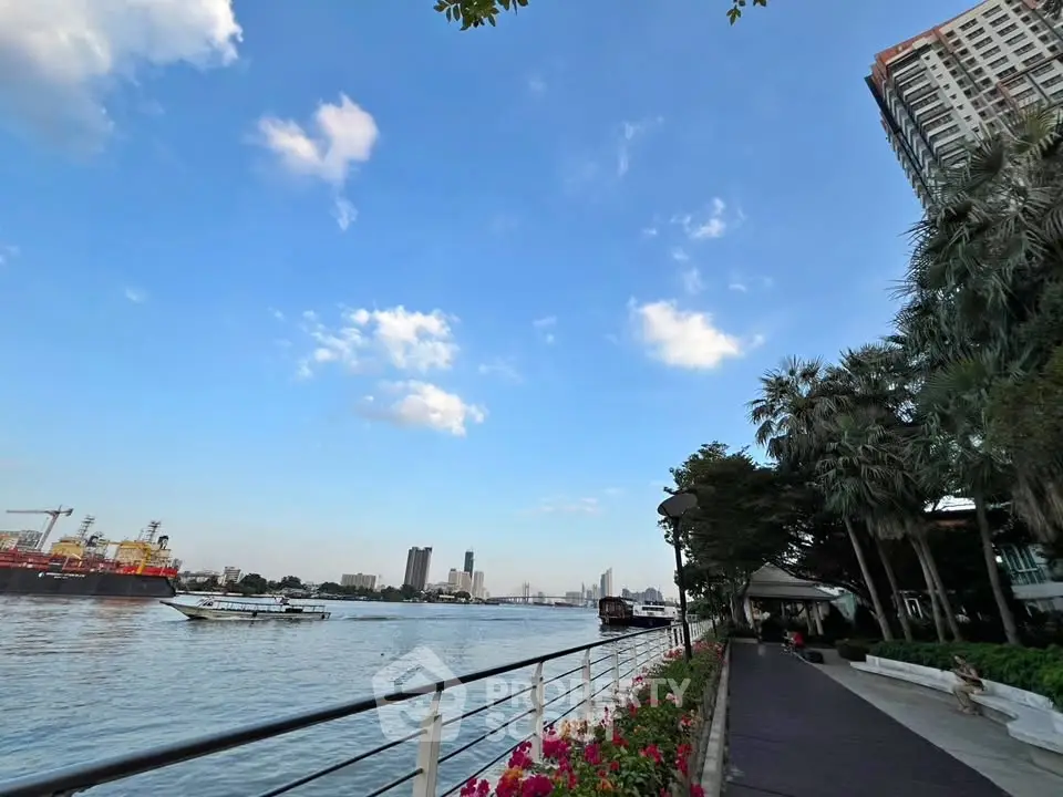 Stunning riverside view with modern high-rise and lush greenery, perfect for urban living.