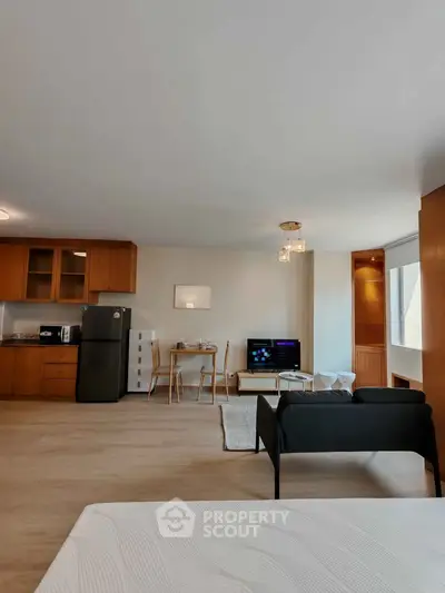 Spacious open-plan living room with modern kitchen and cozy seating area, perfect for entertaining.