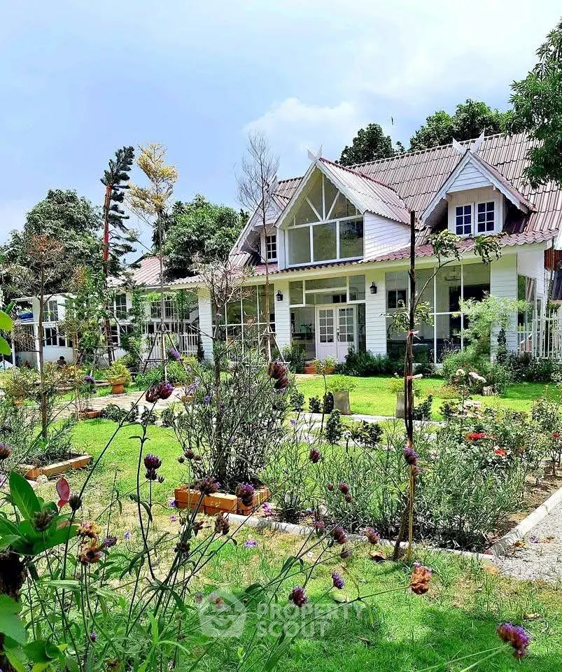 Charming countryside house with lush garden and classic architecture, perfect for serene living.