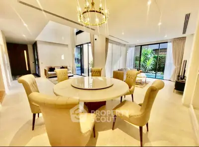 Luxurious open-plan living room with elegant dining area and garden view.