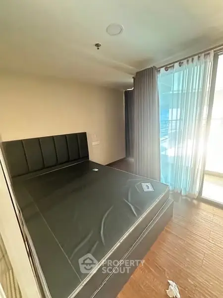 Spacious bedroom with large window and modern bed frame