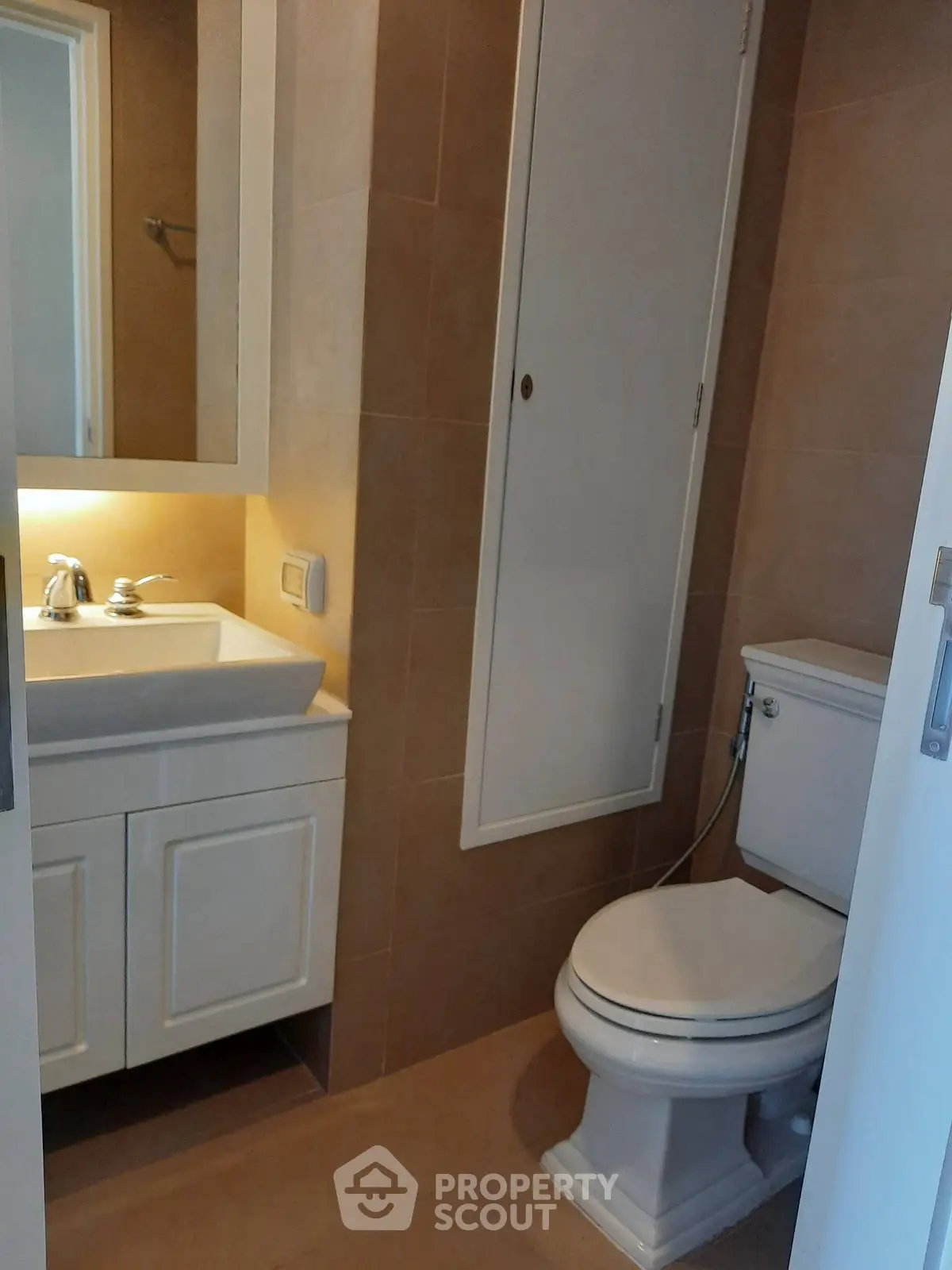 Compact bathroom with modern fixtures and storage cabinet, ideal for efficient space utilization.