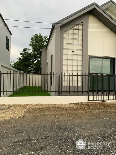 Modern single-story house with sleek design and spacious yard.