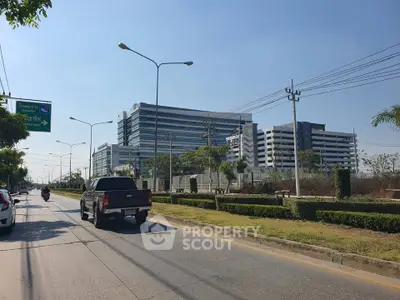 Modern commercial building with sleek architecture and spacious parking area on a sunny day.