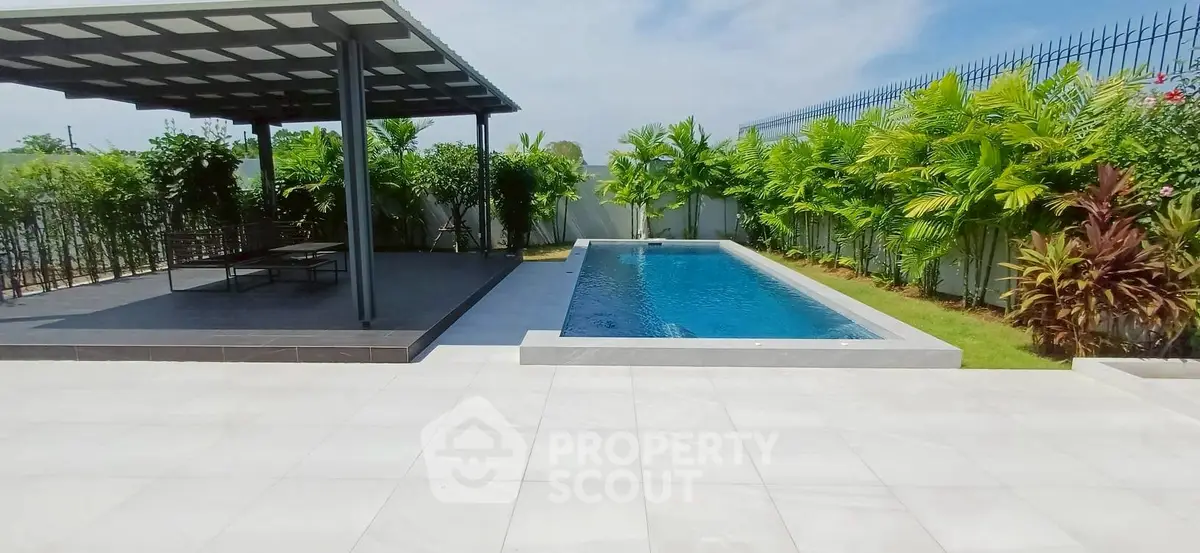 Luxurious backyard with modern pool and shaded lounge area, perfect for relaxation and entertainment.