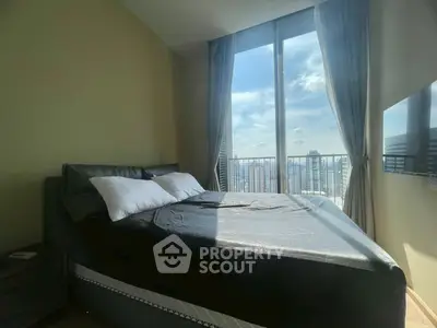 Modern bedroom with large window offering stunning city view and ample natural light.