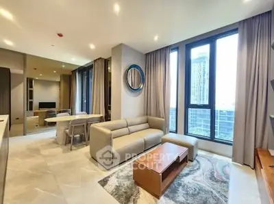 Modern living room with large windows and stylish decor in a high-rise apartment.
