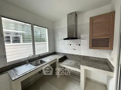 Modern kitchen with sleek countertops and stainless steel range hood