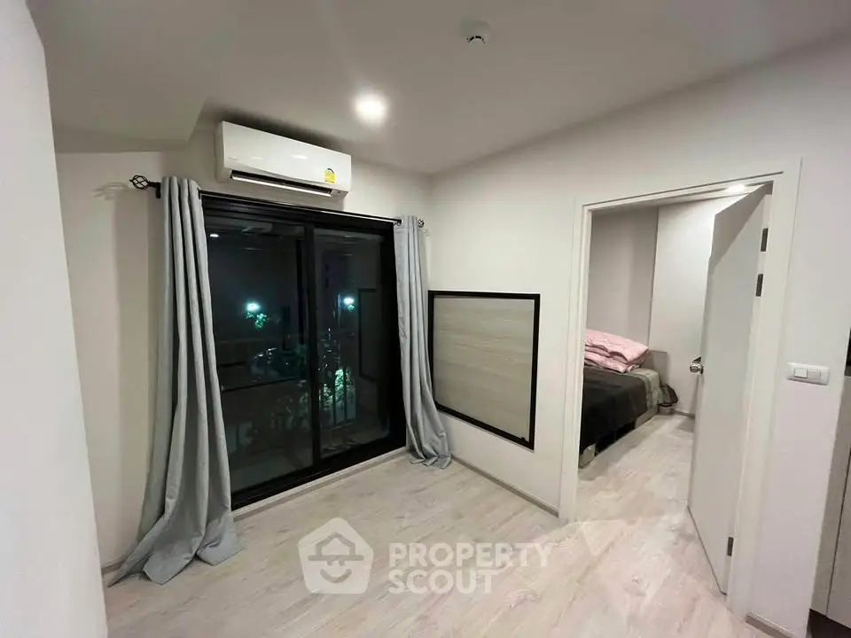 Modern bedroom with balcony access and air conditioning in stylish apartment