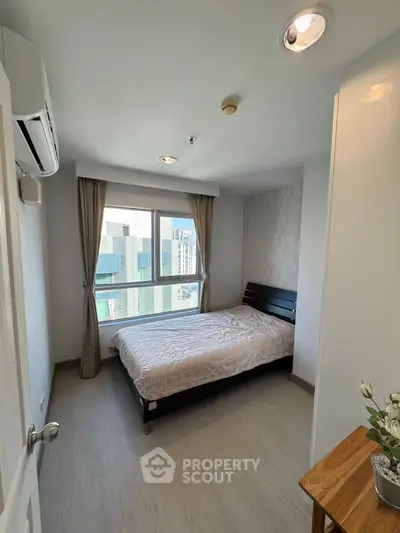 Modern bedroom with large window and stylish decor in urban apartment