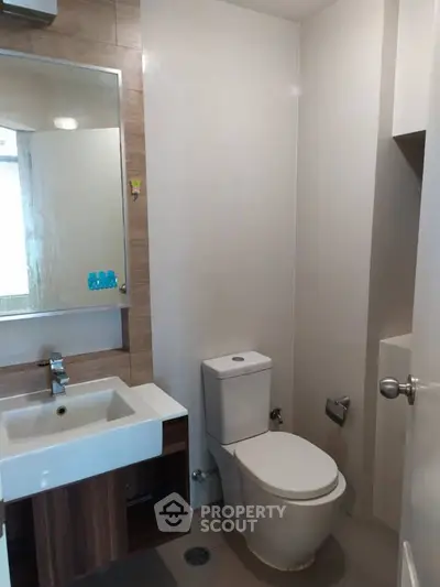 Modern bathroom with sleek fixtures and a large mirror, ideal for contemporary living.