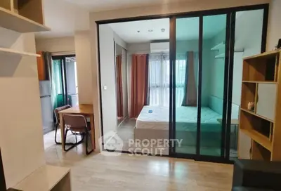 Modern apartment interior with glass partition, cozy bedroom, and compact study area.