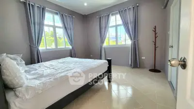 Spacious bedroom with large windows and modern decor