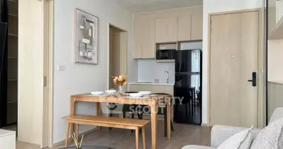 Modern open-plan kitchen and dining area with sleek wooden furniture and contemporary decor.