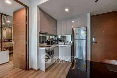 Modern kitchen with sleek cabinetry and stainless steel appliances in a stylish apartment.