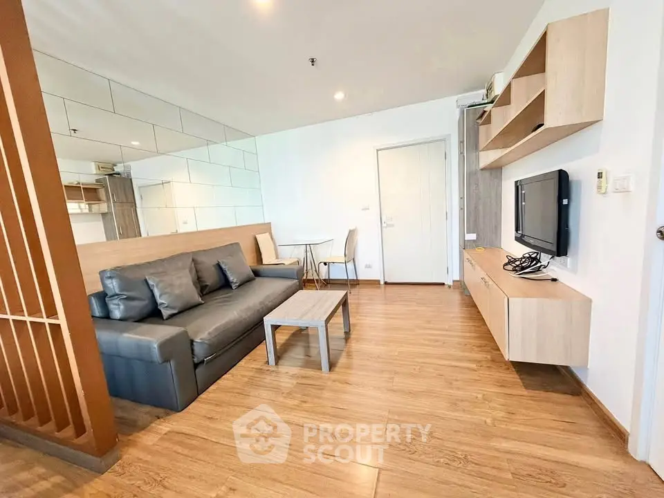 Modern living room with sleek wooden flooring and stylish furniture in a contemporary apartment.