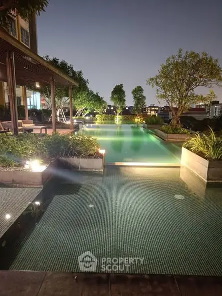 Luxurious rooftop pool with ambient lighting and lush greenery at night.