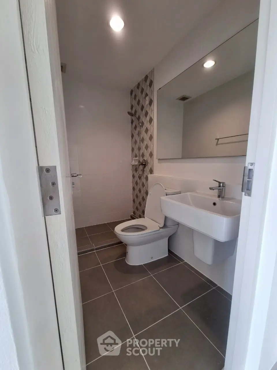 Modern bathroom with sleek fixtures and geometric tile accent wall