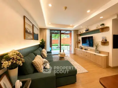 Spacious living room with modern decor and garden view, featuring a large green sofa and wall-mounted TV.