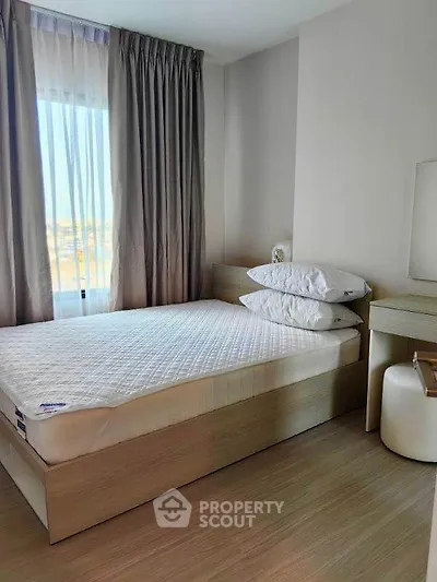 Cozy bedroom with natural light and modern furnishings, perfect for relaxation and comfort.