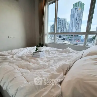 Modern bedroom with city view, large windows, and cozy white bedding.