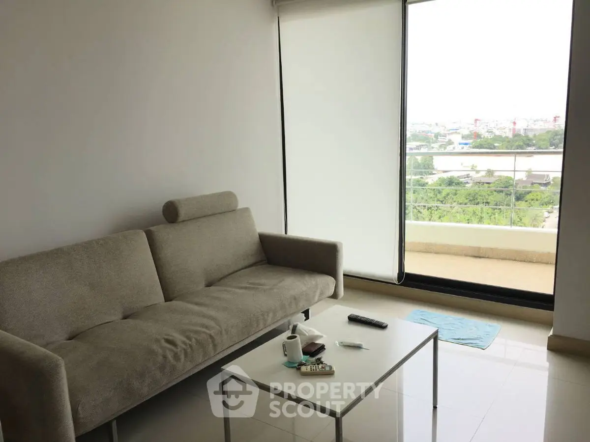 Modern living room with sleek sofa and expansive balcony view.