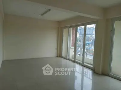 Spacious empty room with large windows and tiled floor, perfect for customization.