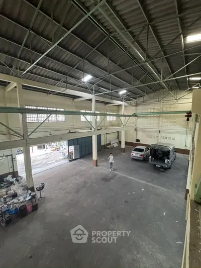 Spacious industrial warehouse with high ceilings and ample parking space.