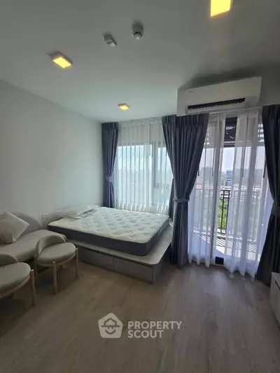 Bright bedroom with large windows and modern furnishings in a stylish apartment.
