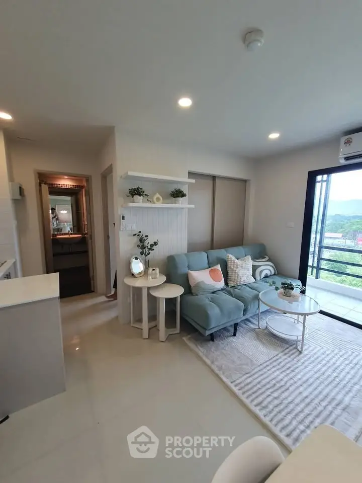 Modern living room with stylish decor and balcony view in a contemporary apartment.
