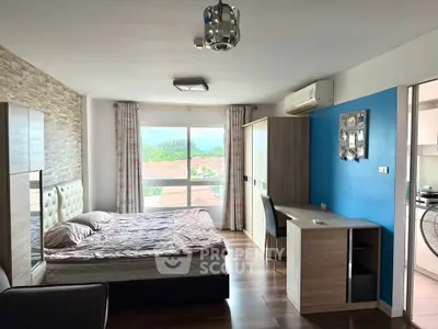 Modern bedroom with stylish decor and large window offering scenic views