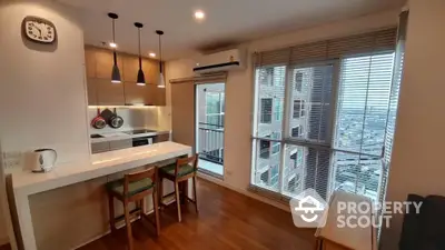 Modern open-layout kitchen with bar seating and city view from balcony