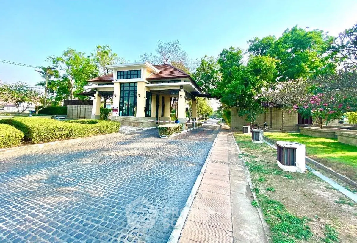Charming gated entrance with lush greenery and modern architecture