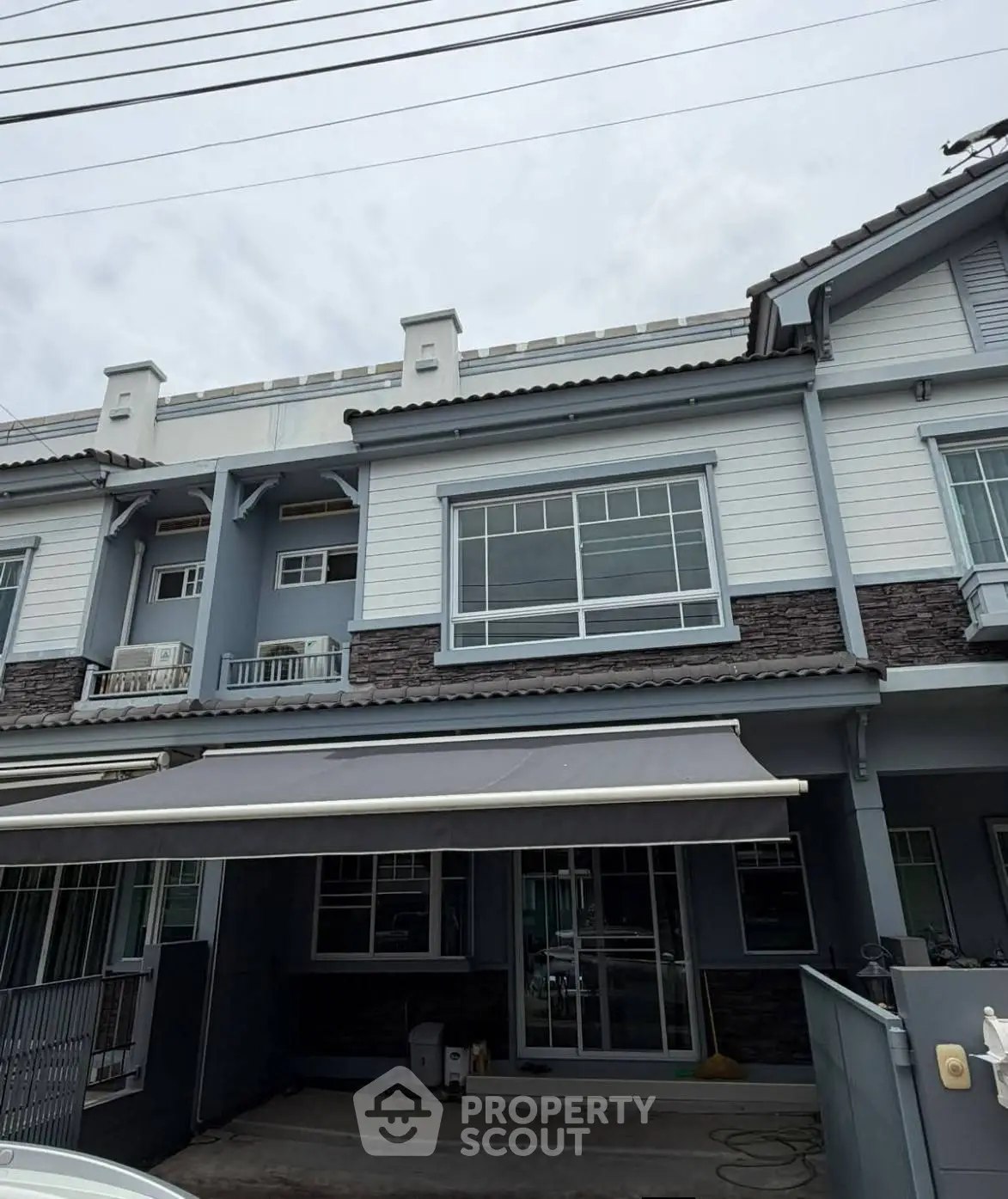 Modern townhouse exterior with large windows and covered parking area.