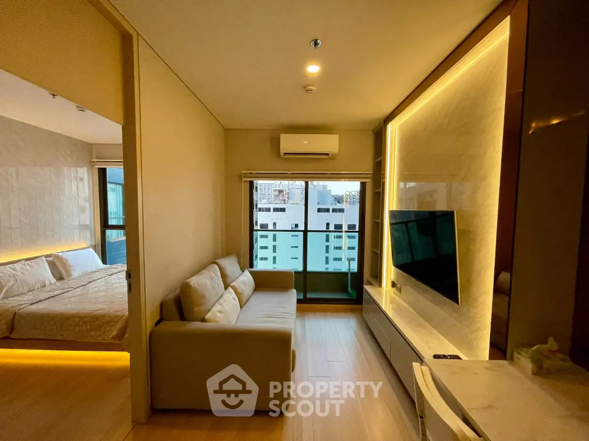 Modern living room with cozy sofa, wall-mounted TV, and balcony view in a stylish apartment.