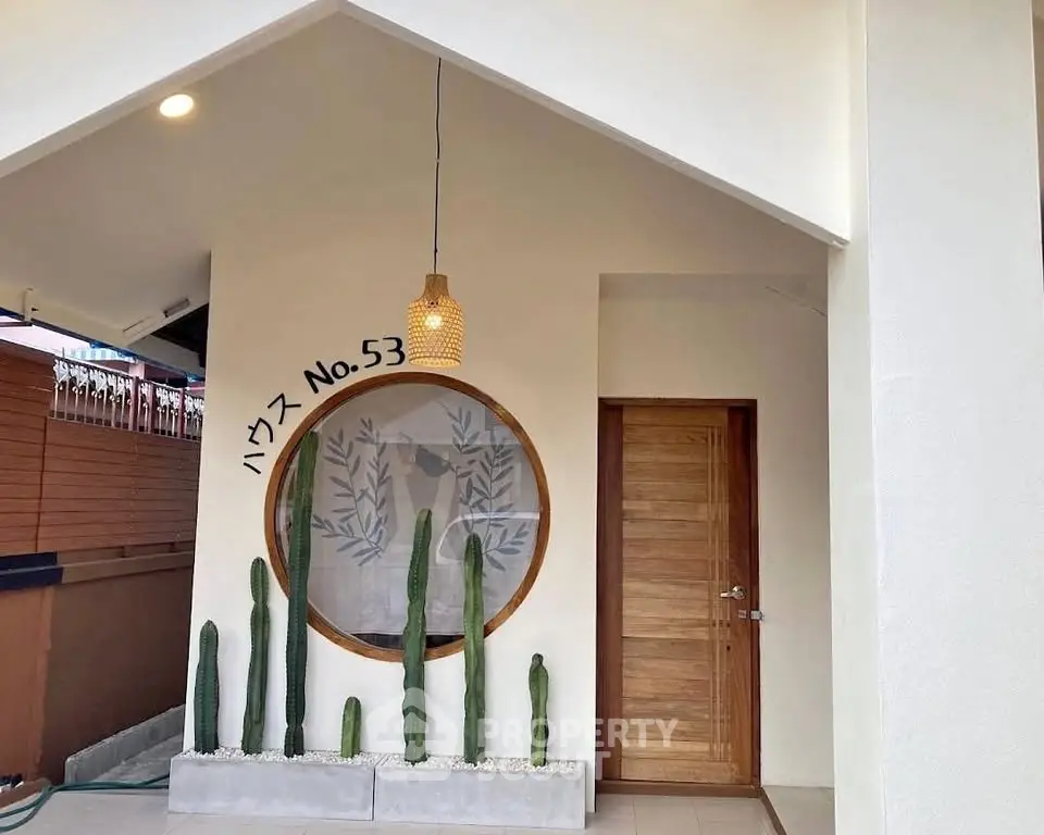 Charming modern entrance with unique circular window and cactus decor at House No. 53.