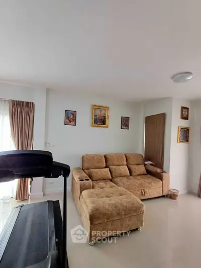 Spacious living room with cozy brown sofa and treadmill, perfect for relaxation and fitness.