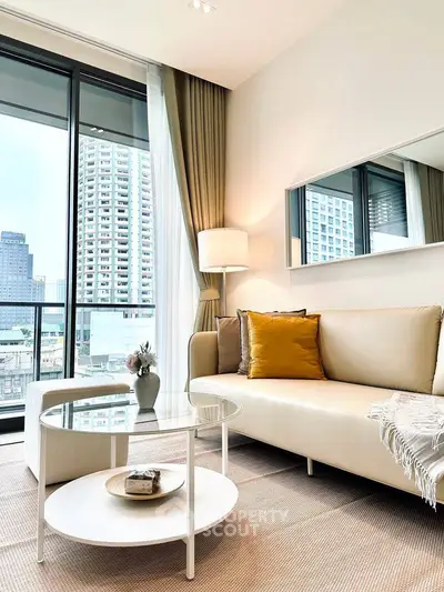 Modern living room with large windows and city view, featuring elegant decor and cozy seating.