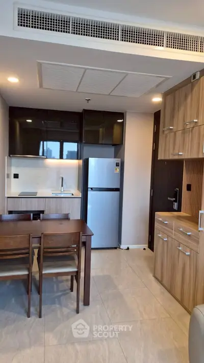 Modern kitchen with sleek cabinetry and dining area in a stylish apartment.