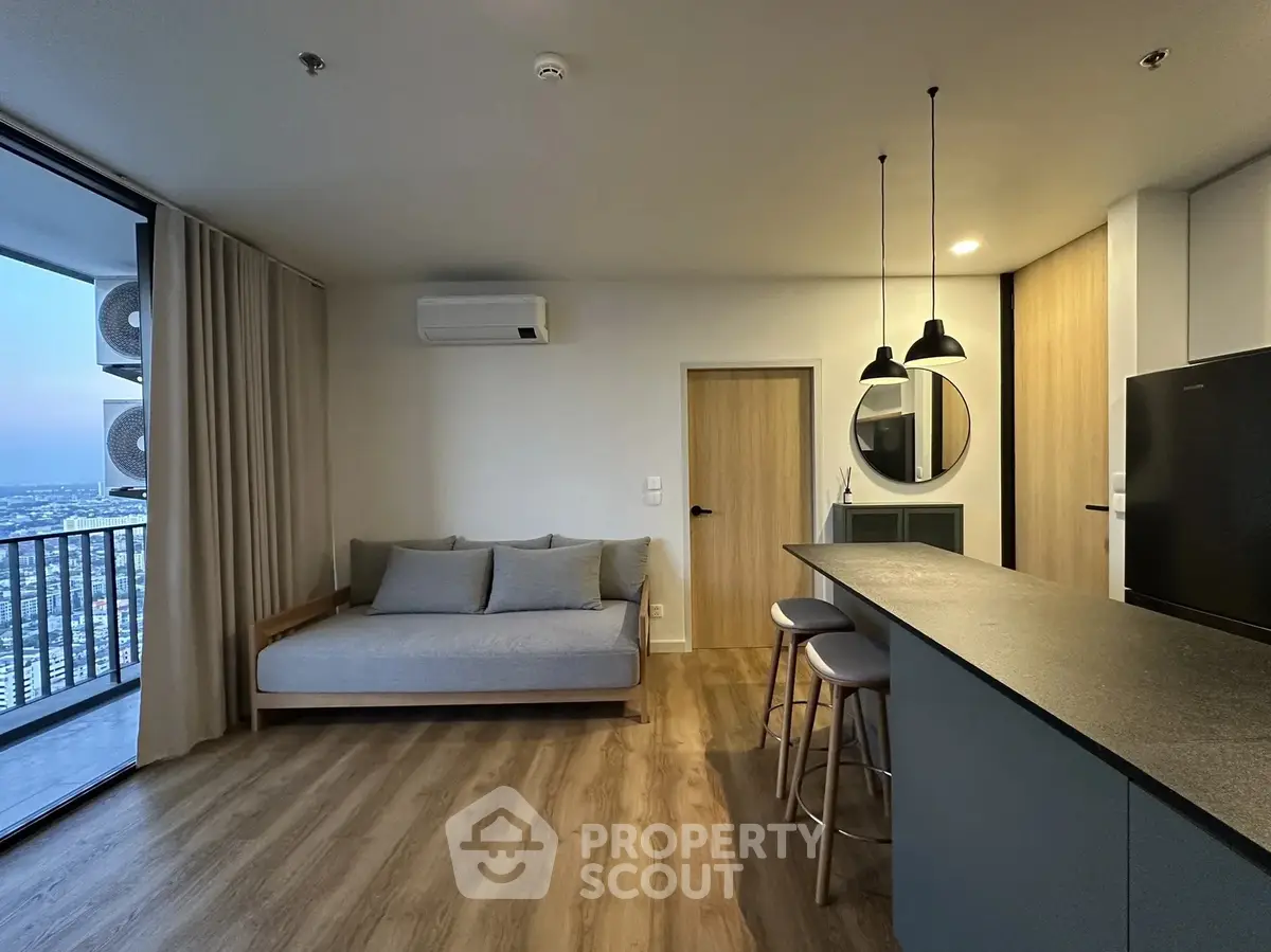 Modern living room with open kitchen and city view balcony in high-rise apartment